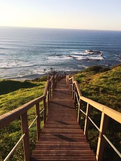 a wooden staircase leading down to the ocean