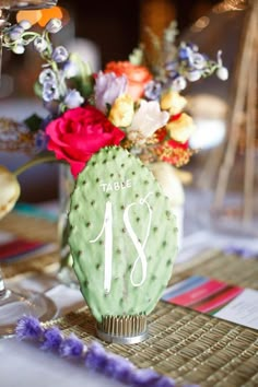 a table with a cactus and flowers on it is set up for a wedding reception