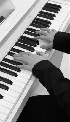 two people are playing the piano together with their hands on top of each other's keys