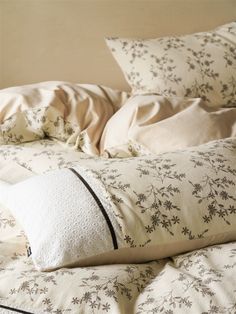 an unmade bed with white and black pillows