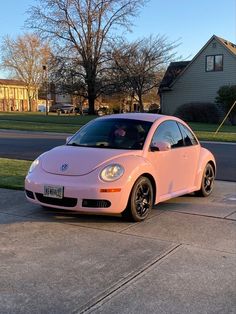 a pink car parked in front of a house