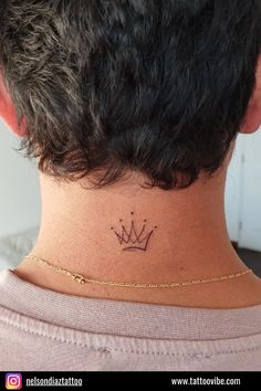 a woman's neck with a crown tattoo on the back of her left shoulder