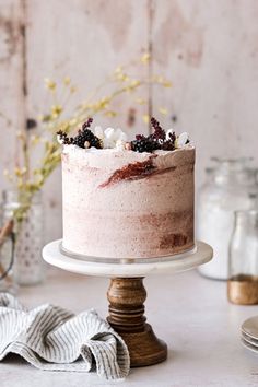 a cake with berries on top sitting on a table