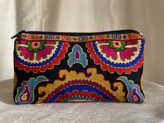 a colorful embroidered purse sitting on top of a table