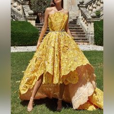 a woman in a yellow dress standing on the grass