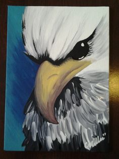 a painting of an eagle's head on a blue background with white and black feathers