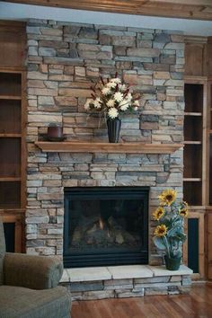 a living room with a fire place and bookcases filled with flowers on the mantle