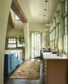 a kitchen with blue cabinets and an area rug