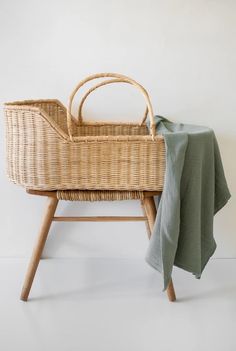 a wicker baby crib with a blue blanket on it