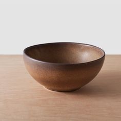 a brown bowl sitting on top of a wooden table