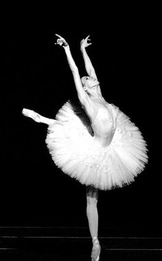 a ballerina in white tutu and leotard with her arms stretched out