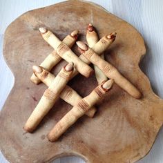 four wooden pegs arranged in the shape of an x on a piece of wood