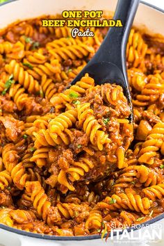 one pot beef enchilada pasta in a skillet with a ladle