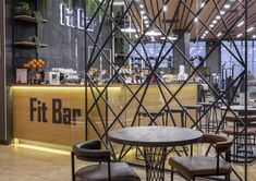 the interior of a restaurant with chairs and tables in front of an open bar area