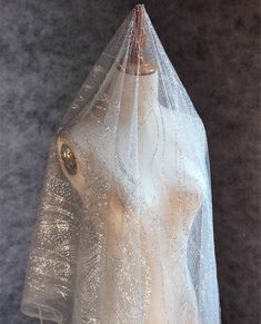 a white veil on top of a mannequin's head covered in sequins