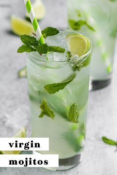 two glasses filled with mojitos sitting on top of a table