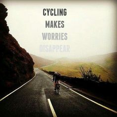 two people riding bikes down the middle of a road with mountains in the background and text saying cycling makes worries disappear