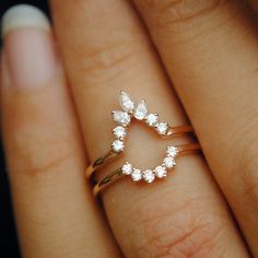 a close up of a person's hand with a ring on their finger and an engagement ring in the middle