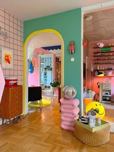 the room is decorated in pastel colors and has an arch leading to another room