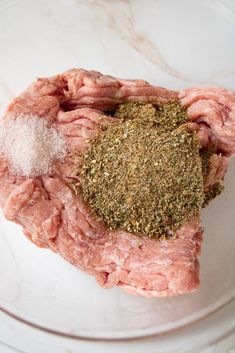 raw meat and seasoning on a white plate