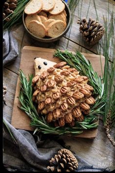 an animal made out of nuts on a cutting board with pine cones and other food items