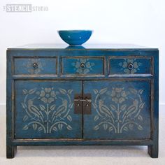 an old blue cabinet with a bowl on top