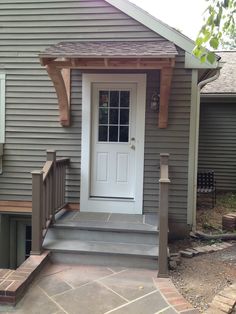 a white door sitting on the side of a gray house