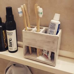 the toothbrush holder is made out of wood and holds several different types of toothpaste