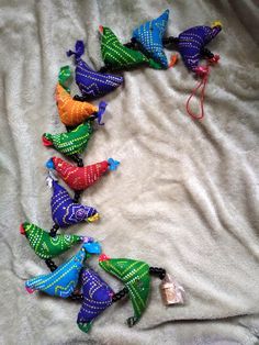 a group of colorful birds sitting on top of a white cloth covered bed next to each other