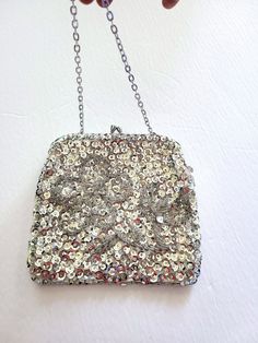 Absolutely gorgeous 60s Du-Val designer silver evening clutch purse with a kiss lock. The purse was made in Hong Kong and is highly decorated with beads and sequin with a beautiful flower beaded in the middle of the bag. The chain and the kiss lock are silver tone, the lining of the bag is silk satin. The bag has never been used before and is in mint condition. The bag will definitely match your evening dress and will also make a beautiful gift! For more items in my store visit: https://www.etsy Vintage Pouch Bag For Party, Retro Silver Rectangular Bag, Retro Silver Rectangular Bags, Vintage Silver Rectangular Clutch, Vintage Silver Clutch As Gift, Vintage Silver Clutch As A Gift, Vintage Pouch Coin Purse For Party, Retro Pouch Bag For Party, Retro Party Pouch Bag