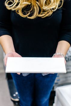 a woman holding a white box in her hands