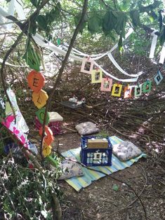 there are many items on the ground in the woods with streamers strung from them