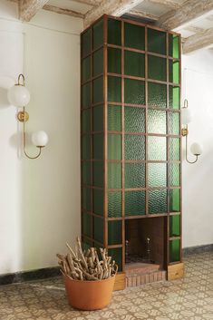 a potted plant sitting next to a fireplace in a room with green glass panels