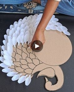 someone is making a turkey out of paper and glues it on the ground with their hands