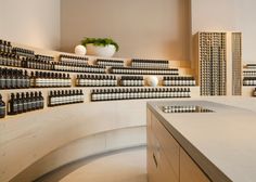 a room filled with lots of bottles of different types and sizes on the wall next to a counter