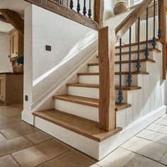 a staircase with wooden handrails and white walls