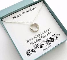 an open box with a necklace in it that reads happy 70th birthday seven rings for seven wonderful decades