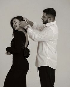 a man helping a woman put on her dress