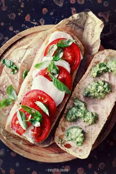 two slices of bread with tomatoes and mozzarella on them, sitting on a wooden platter