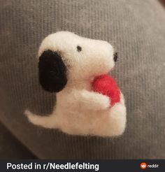 a close up of a stuffed dog with a red ball in its mouth