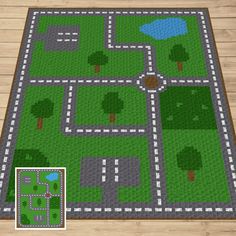 a rug made out of lego blocks with trees and roads on the ground in front of it