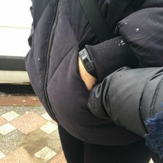 a person with their arm wrapped in a jacket and holding onto the wrist of another person