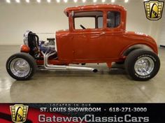 an orange classic car is parked in a garage with the words gateway classic cars on it