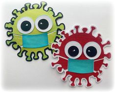 two embroidered patches with eyes and mouths on them, one is green and the other is red