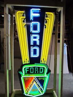 a neon sign that reads ford on it's stand in front of a building