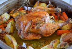 a roasting pan filled with chicken, potatoes and carrots