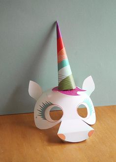 a paper mask with a unicorn's face on it and a party hat on top