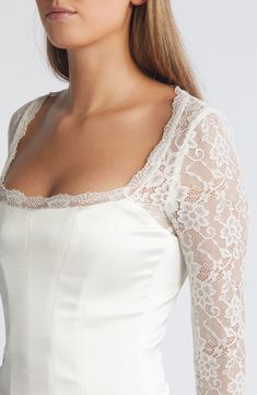 Sheer lace sleeves enhance the romance of a corset-inspired top fashioned with a smooth satin bodice and structured boning. Back zip; keyhole with button-and-loop closure Square neck Long sleeves Lined, with structured boning 100% polyester with 84% polyamide, 16% elastane and 90% polyamide, 10% elastane contrasts Dry clean Imported Elegant Lace Corset For Wedding Night, Elegant Lace Wedding Night Corset, Elegant Lace Wedding Corset, Elegant Corset With Lace Trim And Sweetheart Neckline, Elegant Corset With Sweetheart Neckline And Lace Trim, Elegant Corset With Sweetheart Neckline And Delicate Lace, Feminine Delicate Lace Fitted Corset, Fitted Lace Corset For Wedding Night, Fitted Feminine Corset With Lace Bodice