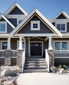 a large house with stone pillars and white railings on the front entrance to it