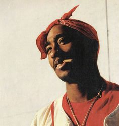 a man with a red turban on his head standing in front of a white wall